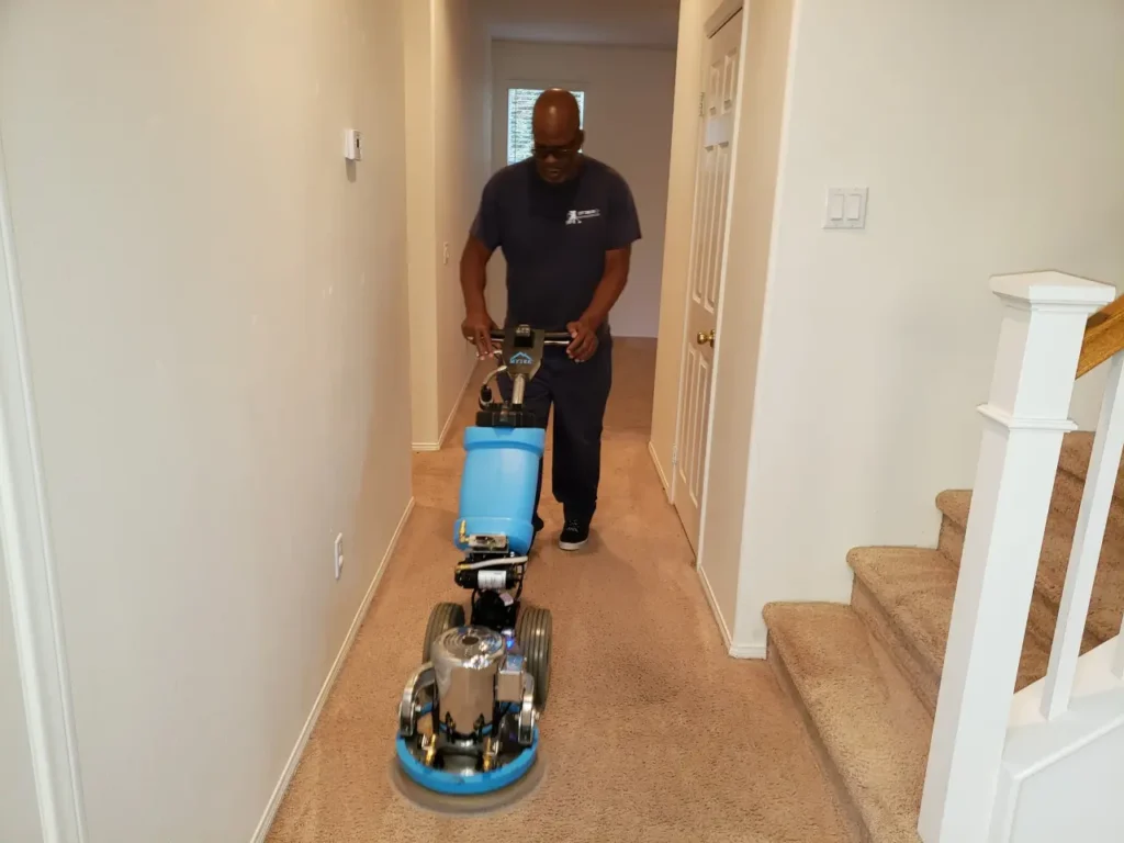Optimum Cleaning technician deep cleaning a hallway carpet